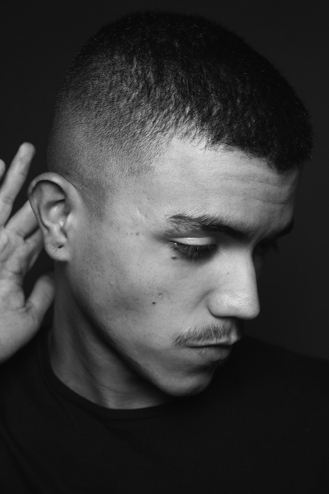 Black and white portrait of a man with a skin fade and short top