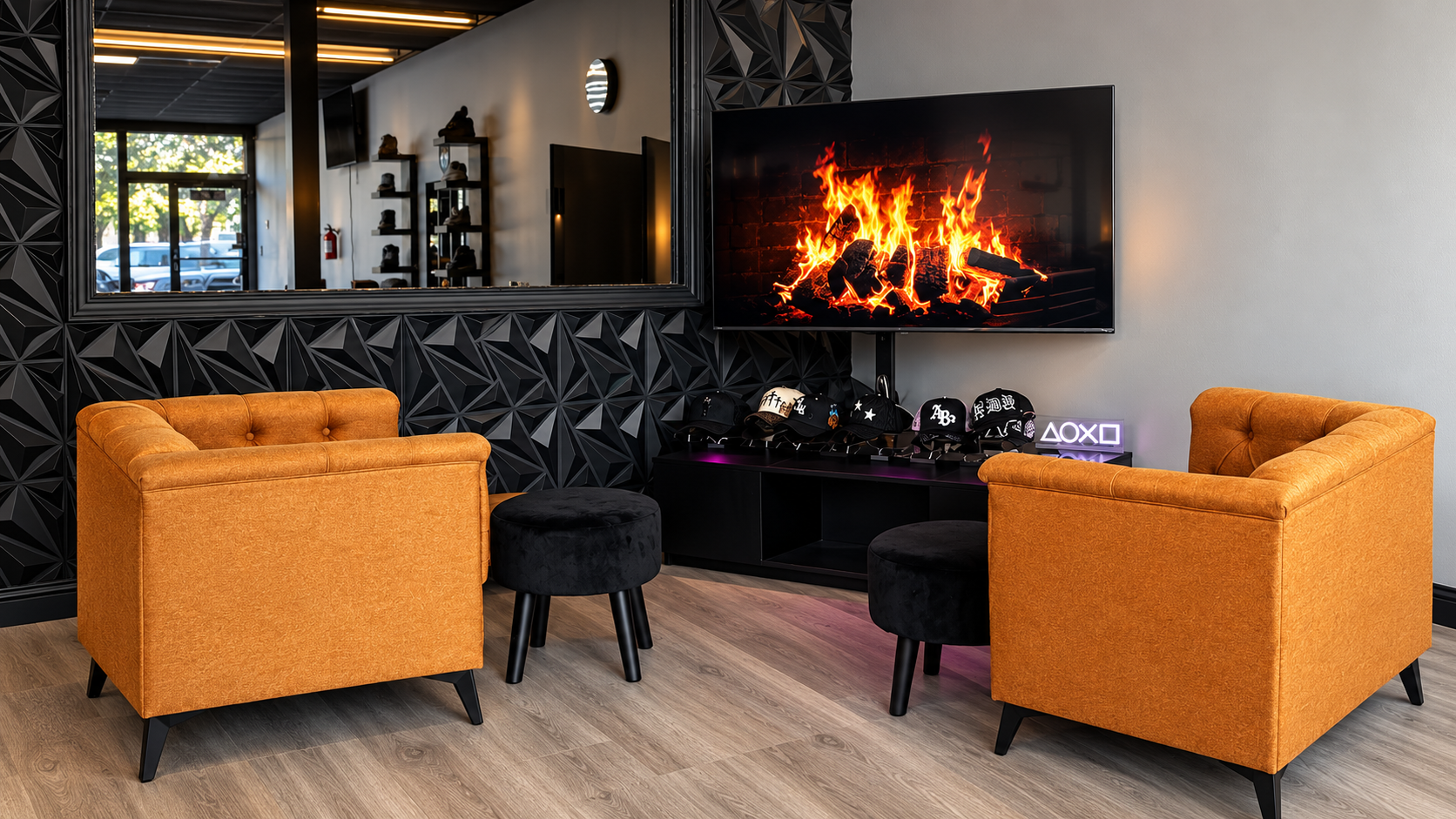 God Level Barbershop waiting lounge: amber armchairs facing a fireplace screen on a black geometric wall