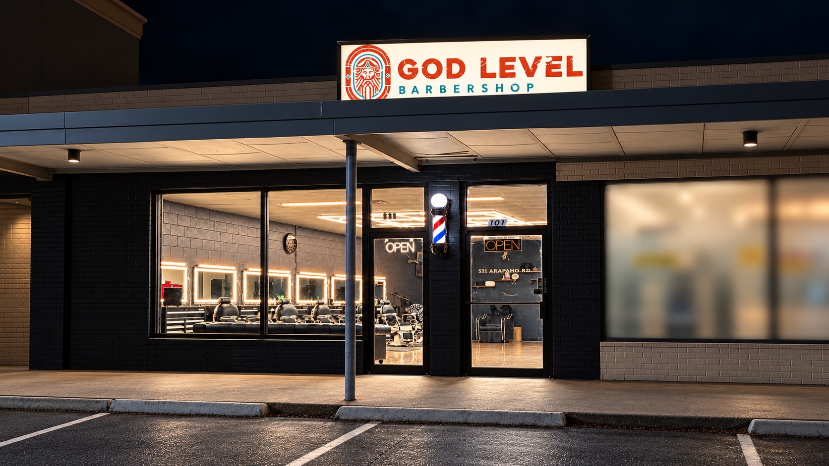 God Level Barbershop storefront at night: lit GOD LEVEL sign, barber pole and glowing windows with chrome chairs inside