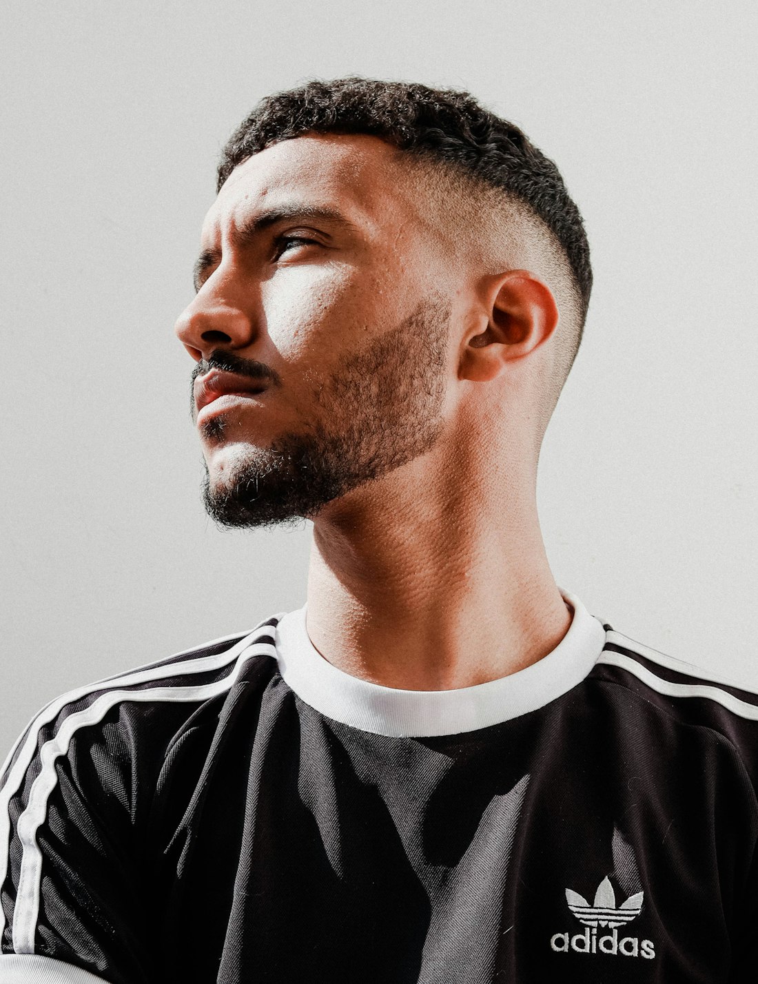Man looking up with a mid fade and short textured top