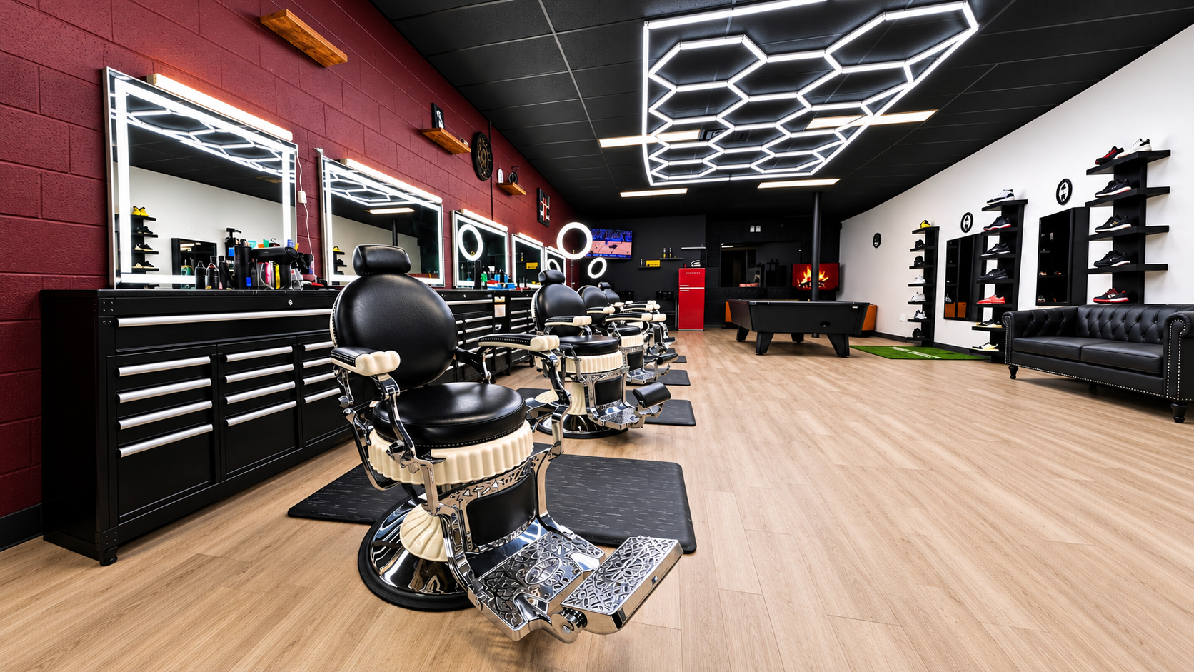 God Level Barbershop interior: chrome barber chairs along the burgundy brick wall, illuminated mirrors and the lounge with the pool table