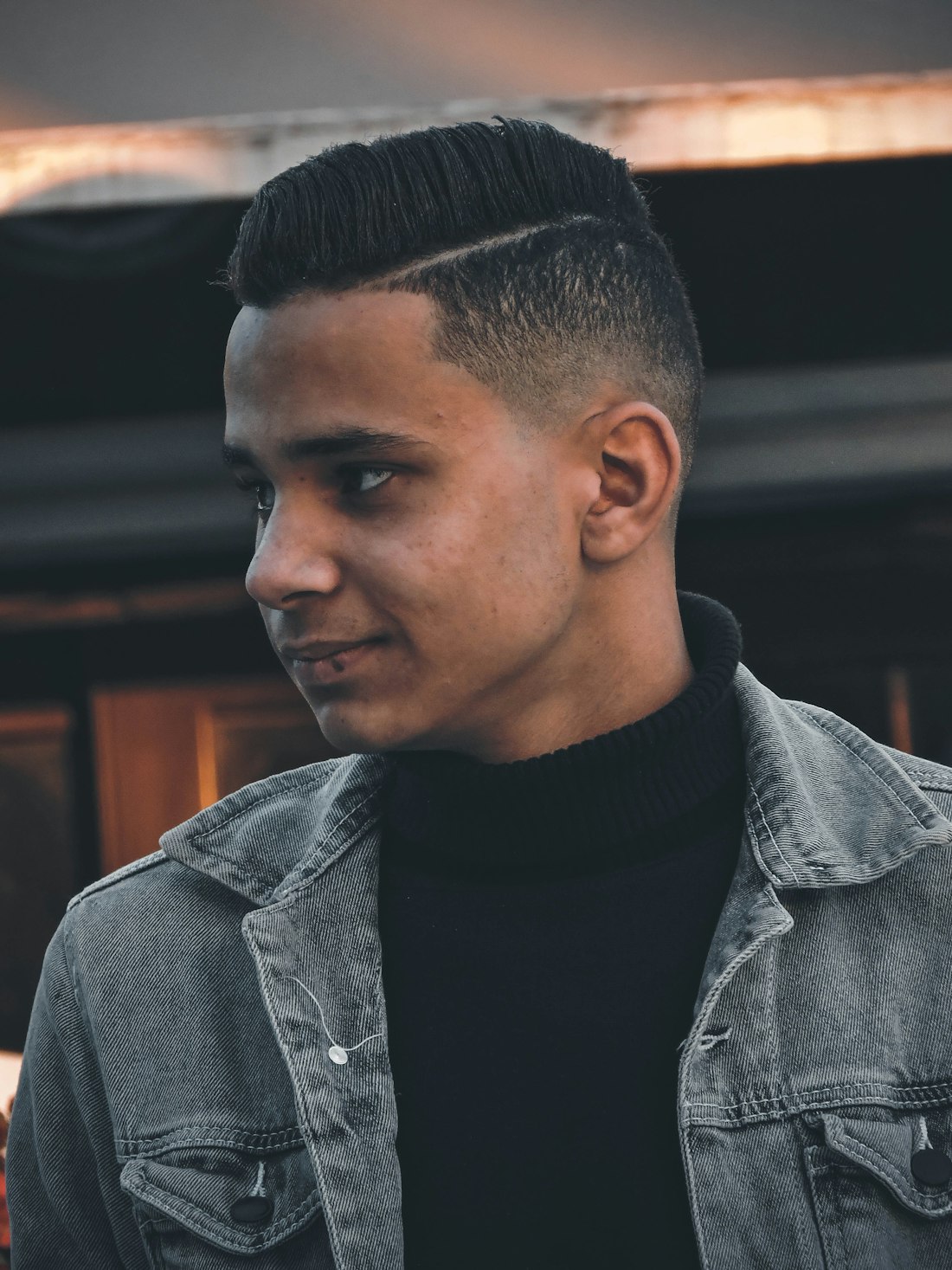 Man with a side-swept top, shaved part line and faded sides